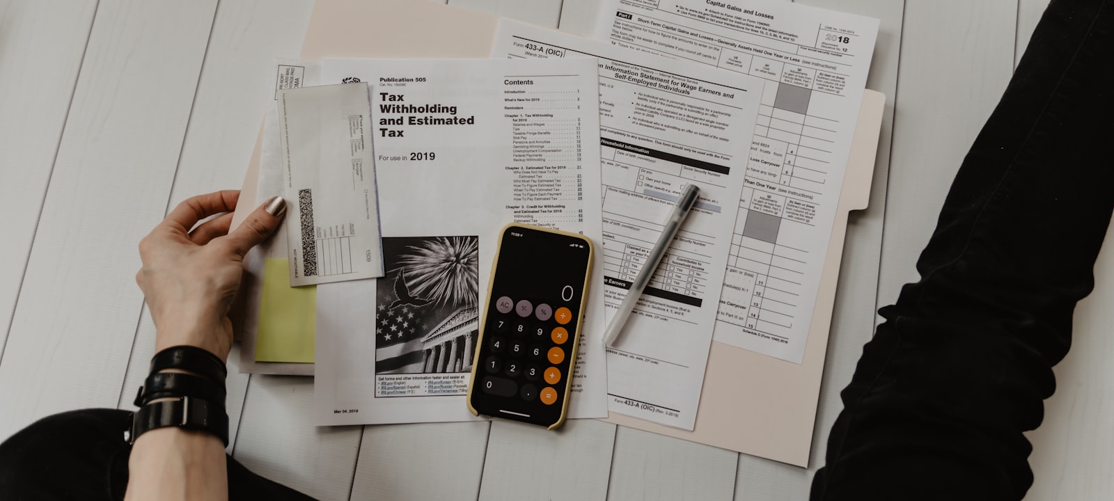 Stacks of financial documents and a calculator on a desk